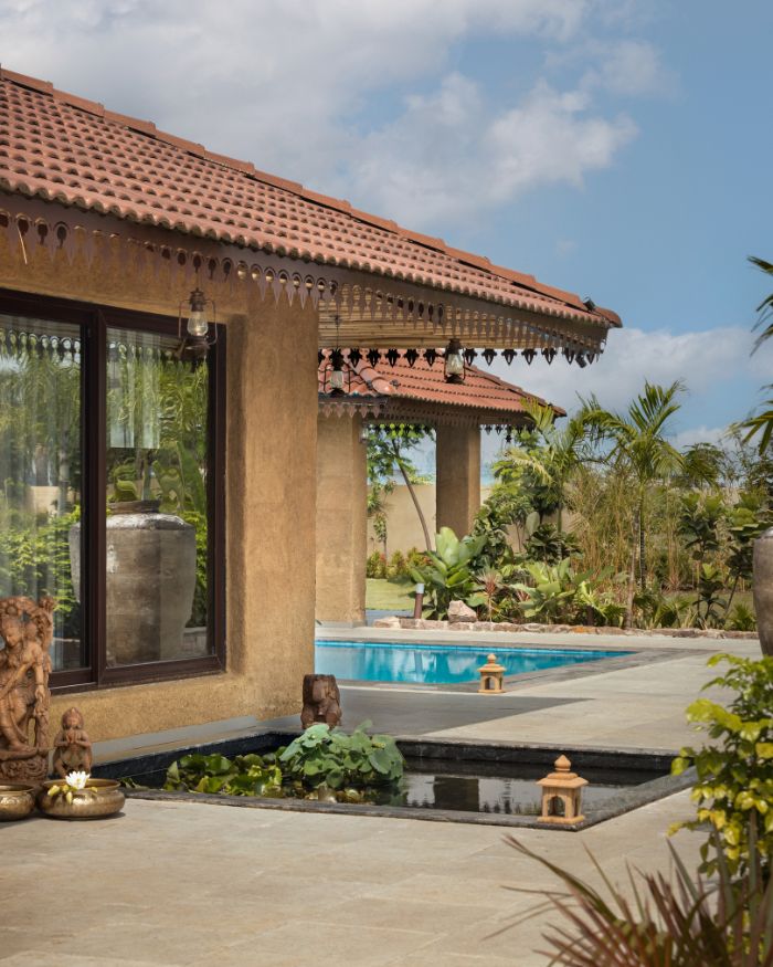 The entry to the living and dining areas is through the center, visually dividing the space into two. This side features a formal seating area, facing the lotus pond and the front yard; Styled by Kiran Thadani,  Photography by Purnesh Dev Nikhanj