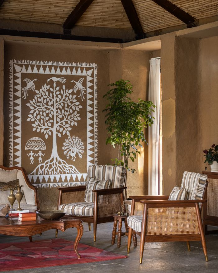 The living area —featuring a painting by a local artist, depicting a tree and peacock dance, brass accents from Bastar Art, cushions from Home Editor by Neha Menghani, furniture from Forms, Nagpur — makes a stunning case for an earthy and rustic design sensibility; Styled by Kiran Thadani, Photography by Purnesh Dev Nikhanj