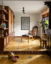 Steeped in colour, the prayer space is headlined by wood, cane, and brass accents. The rocking chair is a Maram Furniture creation and pairs fittingly with the upholstered ottoman by Tusker Katha. Binds by Ind Eclectik drape the traditional-style windows; Photography by Roshan Satish Paliath