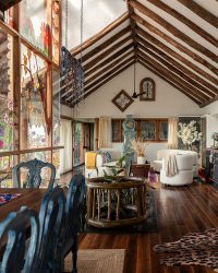 An architectural sleight of hand, the living room’s autumnal reverse-glass painting creates a visual barrier, disrupting the glass’ reflectiveness, discouraging birds from flying into it. The shifting shadows it casts is an added aesthetic benefit; Photography by Vignesh Sivakumar