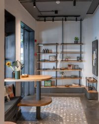 Industrial detailing meets earthy minimalism in the souk-like foyer, enriched by curated objects and pebble inlay flooring; Photography by Kuber Shah