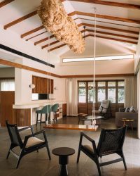 Furniture is by Magari alongside a rustic swing and an art installation hanging from the ceiling inside the living area; Photography by Ishita Batra